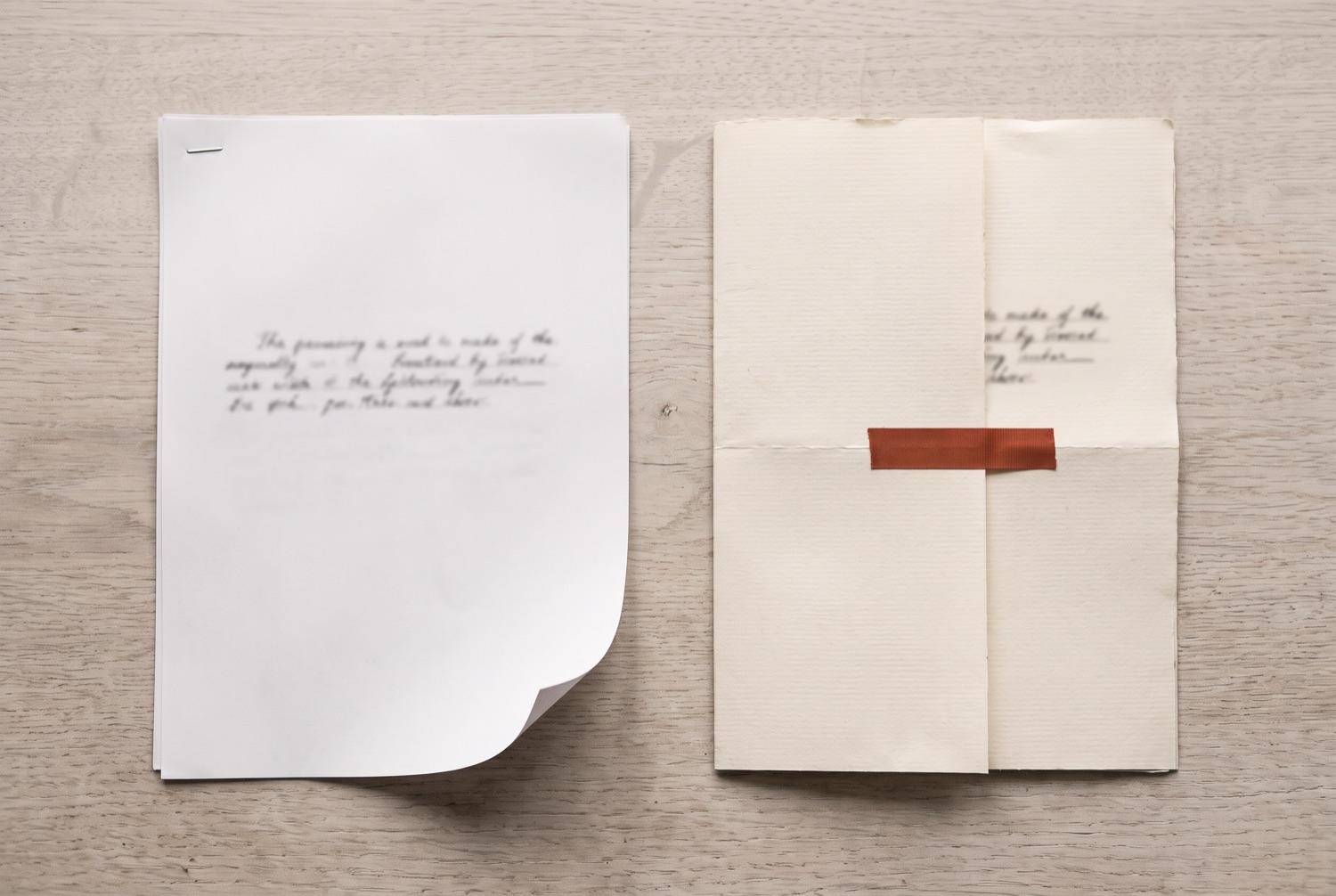 Two copies of the same short document seen from above, the left on thin bright copier paper with a stapled corner and a curling edge, the right on heavy cream laid paper folded in three with a band of terracotta tape across it.