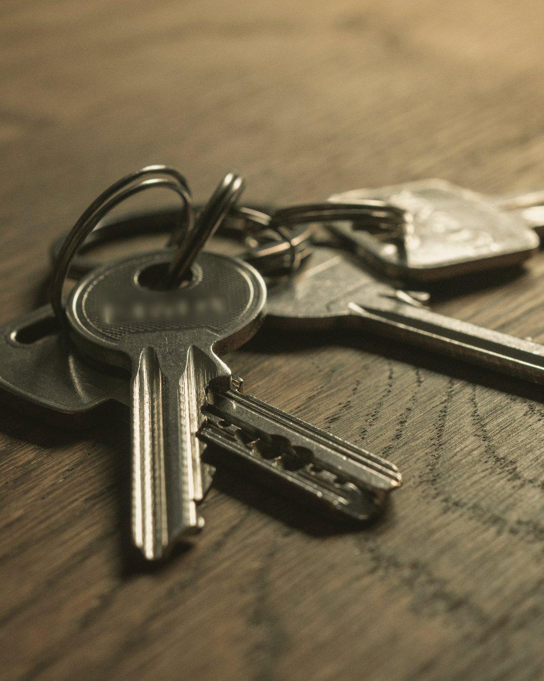 A bunch of house keys on a dark wooden table